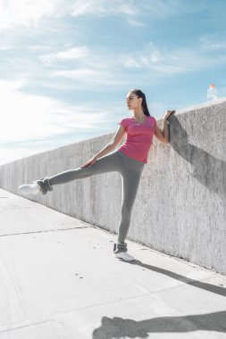 kendine güvenen atletik genç kız bacak yapıyor açık havada egzersiz, spor sever