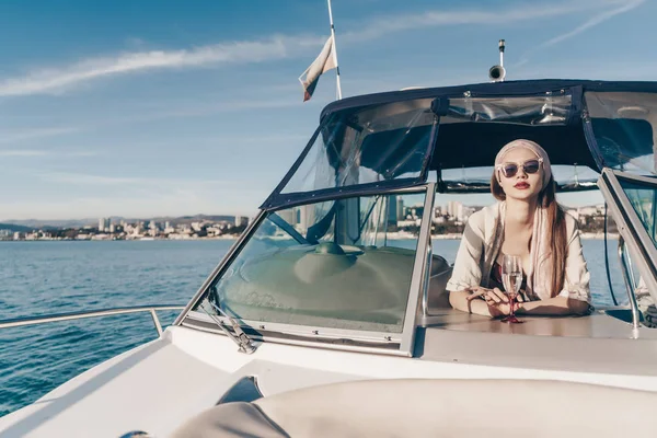 Una mujer rica y lujosa en gafas de sol disfruta de la relajación en su yate, navega en el mar Caribe —  Fotos de Stock