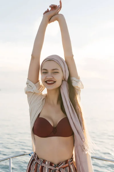 Feliz linda chica joven disfruta relajarse en un yate, sonriendo y posando —  Fotos de Stock