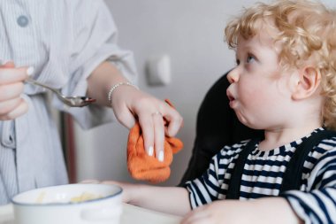 Anne beslemeleri onun küçük kıvırcık çocuğun evlat yararlı çorba ile aile yemeği