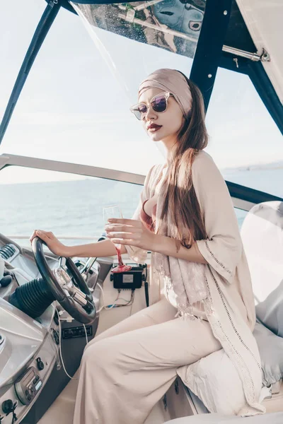 şık yaz giysileri çekici kız onun yatta adalarına yelken zengin bir şampanya içiyor ve bir tatil sahiptir