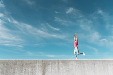 kendine güvenen ince kız mavi gökyüzü altında çalışır, spor için gider ve sağlıklı bir yaşam tarzı olur