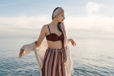 şık giysiler içinde çekici bir zengin kız uzun zamandır beklenen tatil onun yatta sahiptir.
