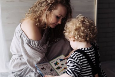 dostu genç Aile, onun küçük oğlu ile oynarken kıvırcık Genç Anne