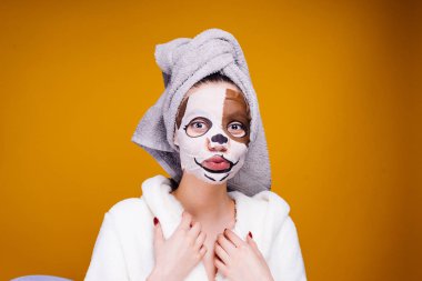 kafasını ve beyaz bornoz havlu ile garip bir genç kız kendini sonra bir köpeğin yüz nemlendirici maske yüzünde görünüyor