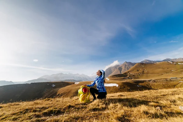Активная девушка в синей куртке путешествует по Кавказским горам с рюкзаком и палаткой — стоковое фото