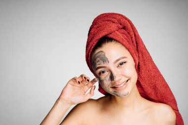 başında kırmızı bir havlu ile güzel gülümseyen kız kendini önemser, içine belgili tanımlık fotoğraf makinesi ve gülümsüyor görünüyor