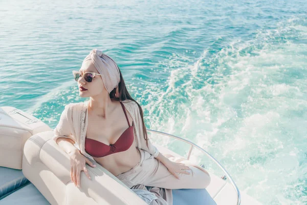 Hermosa mujer rica en gafas de sol disfruta de las vacaciones tan esperadas en su yate blanco —  Fotos de Stock