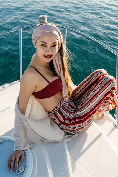 Luxurious young woman in stylish summer pants posing on her white yacht, floating on the islands on vacation — Stock Photo, Image