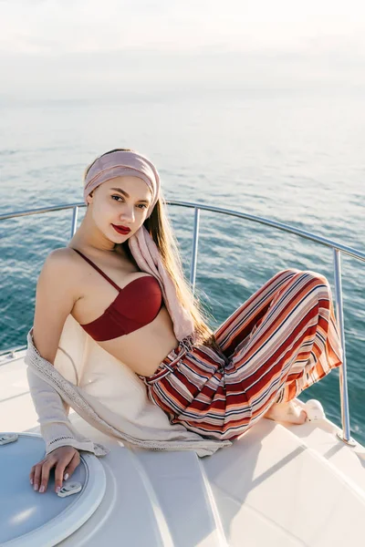 カリブの海でセーリング、ヨットの上でポーズをとって夏服の美しい若い女性 — ストック写真