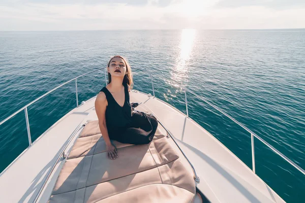 Egy vonzó gazdag lány élvezi a tengeri út és a vakáció a fehér jacht, jelent — Stock Fotó