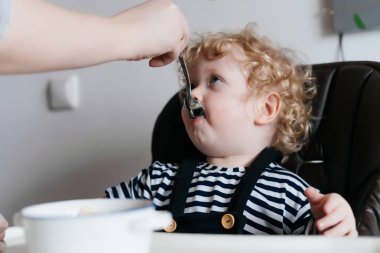 Anne beslemeleri küçük kıvırcık oğlu yararlı çorba ile bir aile kahvaltı