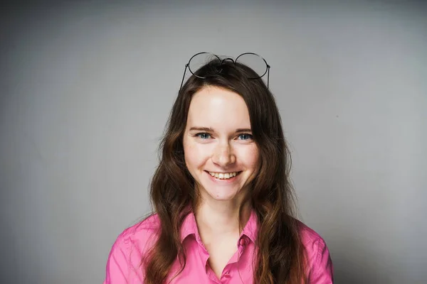 Feliz jovem trabalhador de escritório mulher em uma camisa rosa sorrindo e olhando para a câmera — Fotografia de Stock