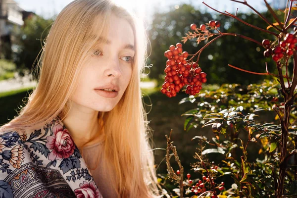 Mladá dívka s modrýma očima blondýnka chodí po zahradě, se těší teplo a sluníčko — Stock fotografie