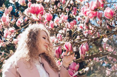 kıvırcık zarif kadın park, bahar sıcak hava ve güneş bir yürüyüş sahiptir