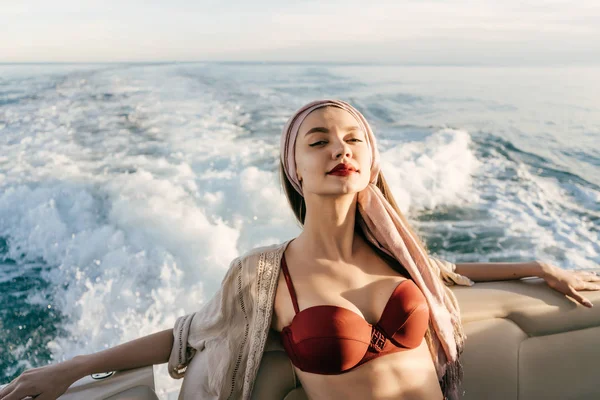Egy luxus gazdag nő a fürdőruhát élvezi a tengeri út és a vakáció a vele fehér jacht — Stock Fotó