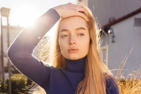 Krásná dívka s modrýma očima blondýnka procházky venku na slunci a pózování — Stock fotografie