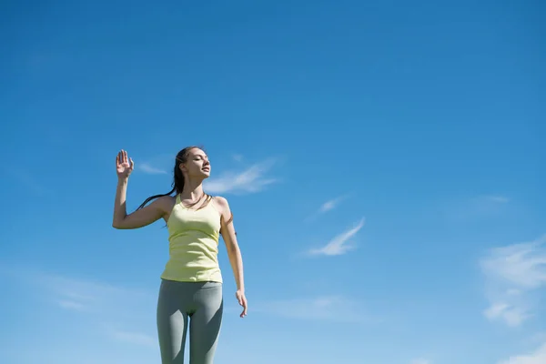 Delgada chica atlética descansando después de trotar bajo el cielo azul, ganando fuerza — Foto de Stock