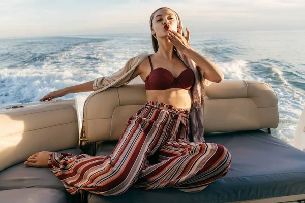 Egy luxus fiatal nő a divatos nyári nadrág nyugszik a yacht, és élvezi a tenger voyage — Stock Fotó