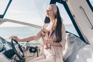 çekici bir genç kadın onun yat çalışır, şampanya içiyor ve deniz sahiptir yolu