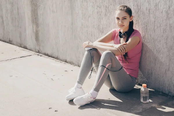 トレーニングと強さを増している後休んで屋外で、地面に座って自信を持ってスポーツ少女 — ストック写真