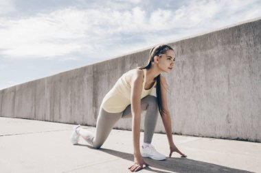 spor oynarken güçlü genç kız açık havada, bir maraton koşmak hazır Başlarken