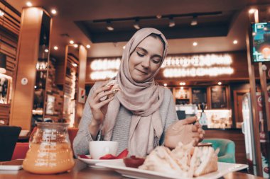 bir başörtüsü başında güzel Arap kızla bir restoran, lezzetli yemek akşam