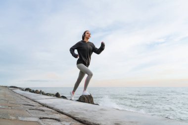 kulaklıklar müzik dinlemek emin etkin kız deniz kenarında, koşu