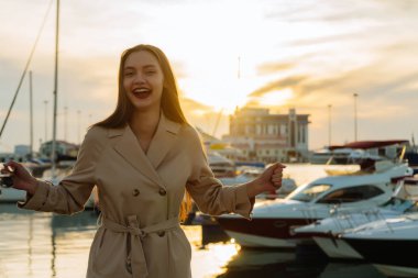 Doğa ve sıcaklık zevk teknesini limanda bekleyen güzel bir kadın gülüyor