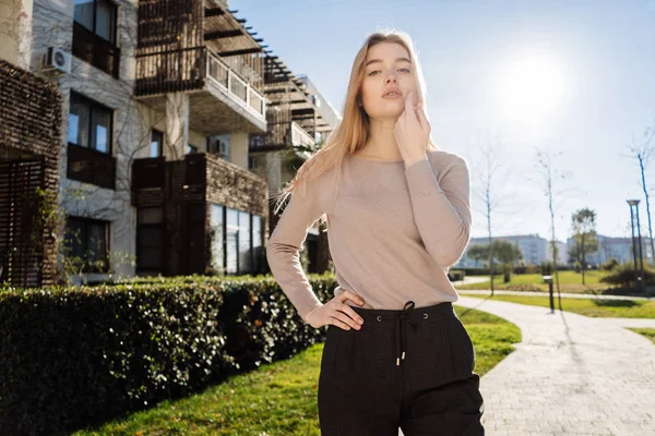 Elegante ragazza modello biondo in abiti alla moda in posa all'aperto al sole — Foto Stock