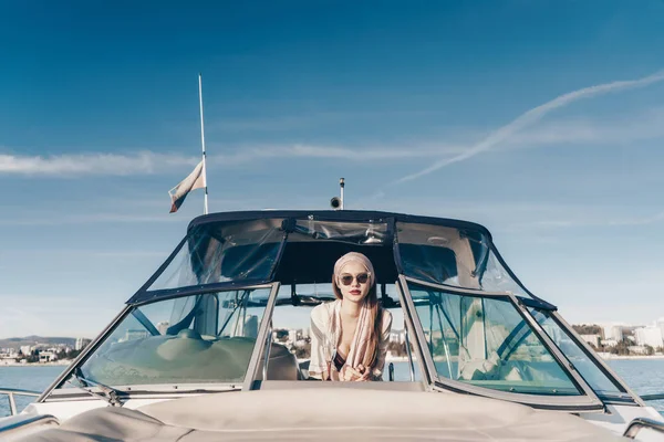 Elegante mujer rica en gafas de sol nada en un yate blanco de vacaciones en la isla, al sol —  Fotos de Stock