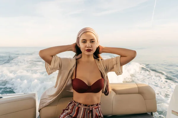 Atractiva joven en ropa de verano elegante posando en un barco, flotando en el mar de vacaciones —  Fotos de Stock