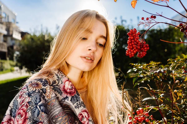 Linda joven rubia caminando en el jardín, disfrutando de la calidez y la primavera en el sol — Foto de Stock