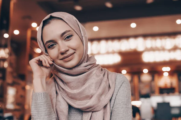 Szép muszlim lány ül egy étteremben, mosolyog, és várja őt étel — Stock Fotó