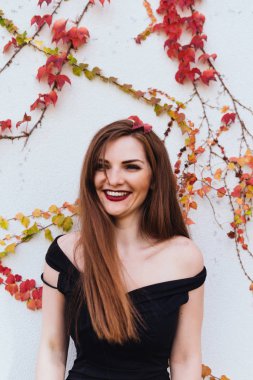 güzel genç uzun saçlı kadın onun bahçesinde, dinlenme ve rahatlatıcı duvara poz