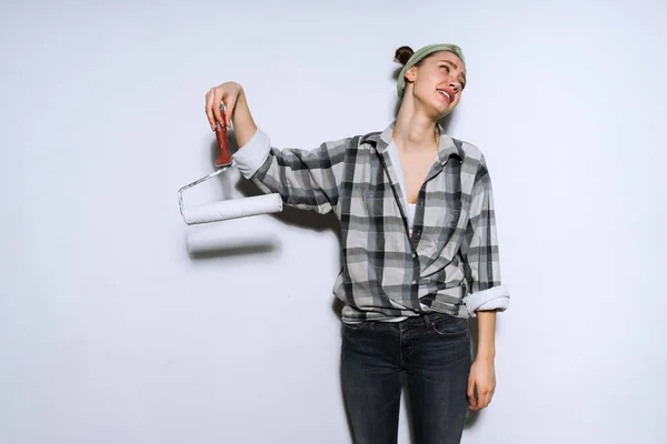 Jong meisje moe van het doen van reparaties, houdt roller voor schilderen muren — Stockfoto