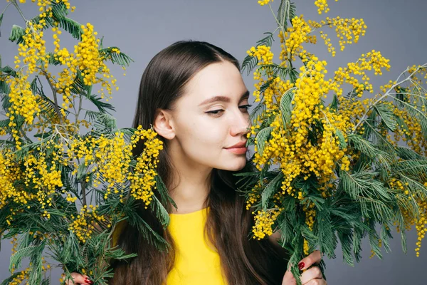 çekici çekici kız sarı mimoza kokusu sahiptir, bahar ve çiçekleri seviyor