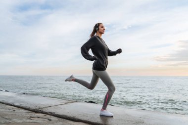 deniz kıyısındaki koşu emin hızlı genç kız runner kulaklıklar müzik dinlemek