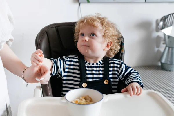 bir sandalye, Anne beslenme yulaf lapası, ailece kahvaltı mutfakta oturmuş kıvırcık küçük oğlu
