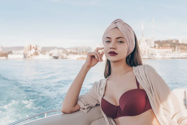 Una joven de lujo en un traje de baño que descansa en su yate y disfruta de un viaje por el mar —  Fotos de Stock