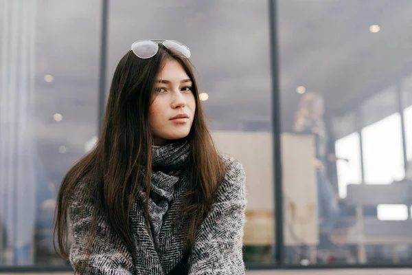 Милий міська брюнетка дівчина в сірому пальто позує на відкритому повітрі, стиль і мода — стокове фото