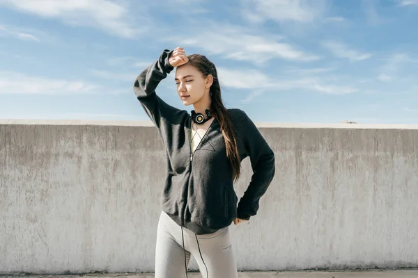 Zelfverzekerd meisje in stijlvolle sporten kleren buitenshuis poseren, leidt een actieve en gezonde levensstijl — Stockfoto