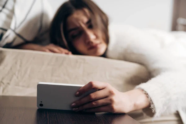 Triste ragazza scontenta si svegliò presto la mattina a causa della sveglia sullo smartphone — Foto Stock