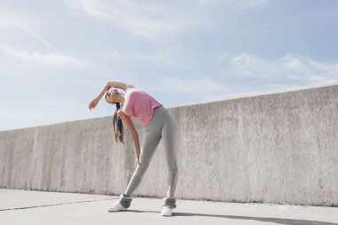 ince atletik kız warmes yukarı ve açık havada önce eğitim uzanıyor