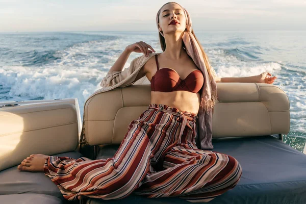 şık yaz giysileri çekici genç kadın onun yatta oturur, rahatlatır ve rahatlatır