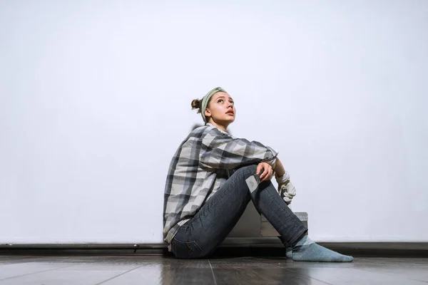 Jovem triste cansado de fazer reparos, sentado no chão em seu apartamento — Fotografia de Stock