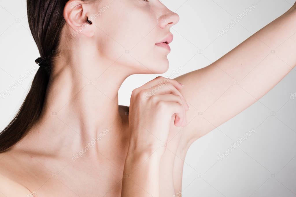beautiful young girl with clean skin demonstrates armpits without hair, after shower