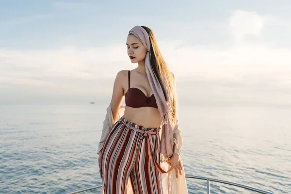 Luxusní krásná dívka v stylových letních šatech pózuje na její jachtě na slunci, se těší na dovolenou — Stock fotografie