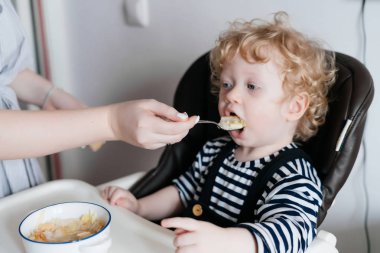 bakım iyi anne küçük kıvırcık çocuk oğlu lezzetli bir çorba ile beslenir.