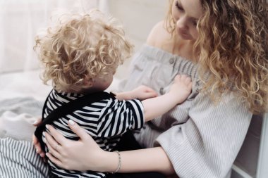 birlikte vakit annesinin kollarında oturan kıvırcık küçük oğlu